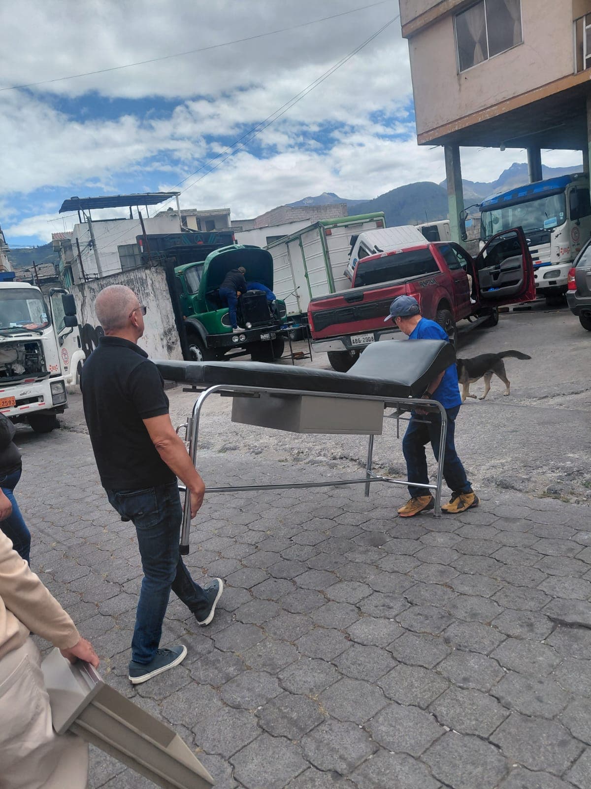 Voluntarios trasladando una camilla de terapia hasta la vivienda de la beneficiaria