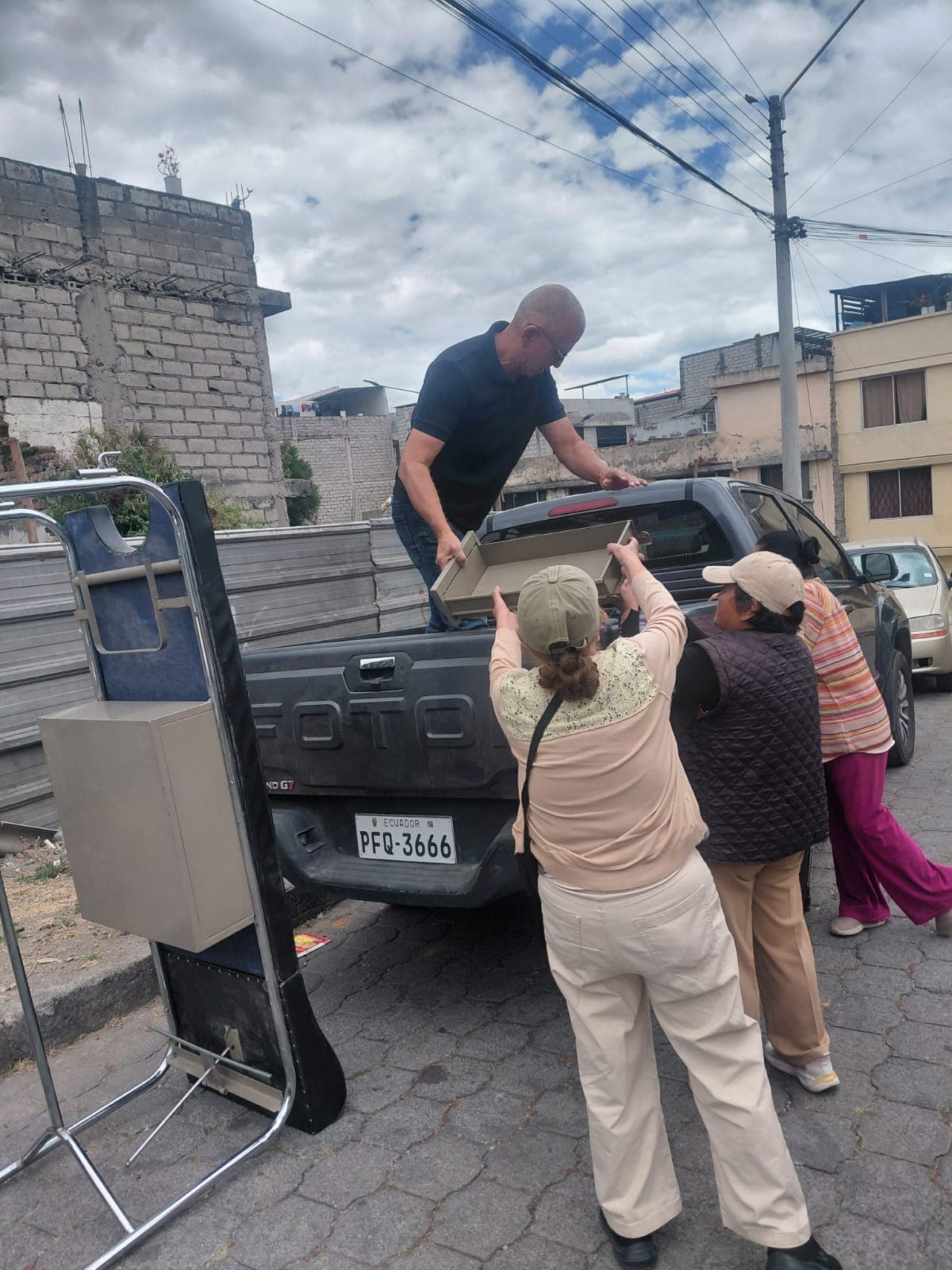 Voluntarios descargando una gaveta desde la camioneta durante la entrega de ayuda social