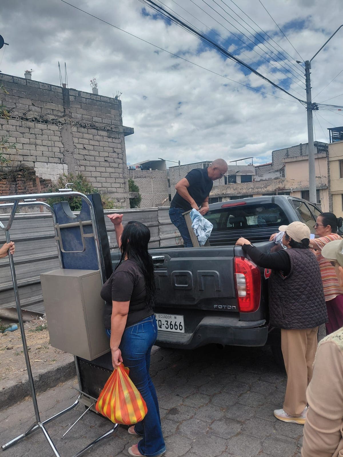 Voluntarios descargando insumos desde la camioneta durante la entrega de ayuda social