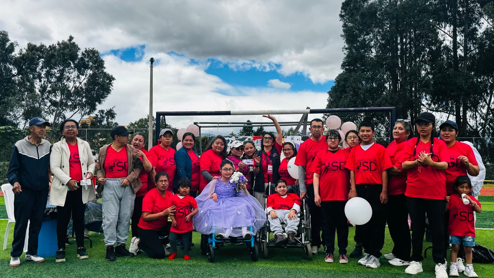 Grupo grande de familias, voluntarios y beneficiarios de HSD reunidos en un evento comunitario