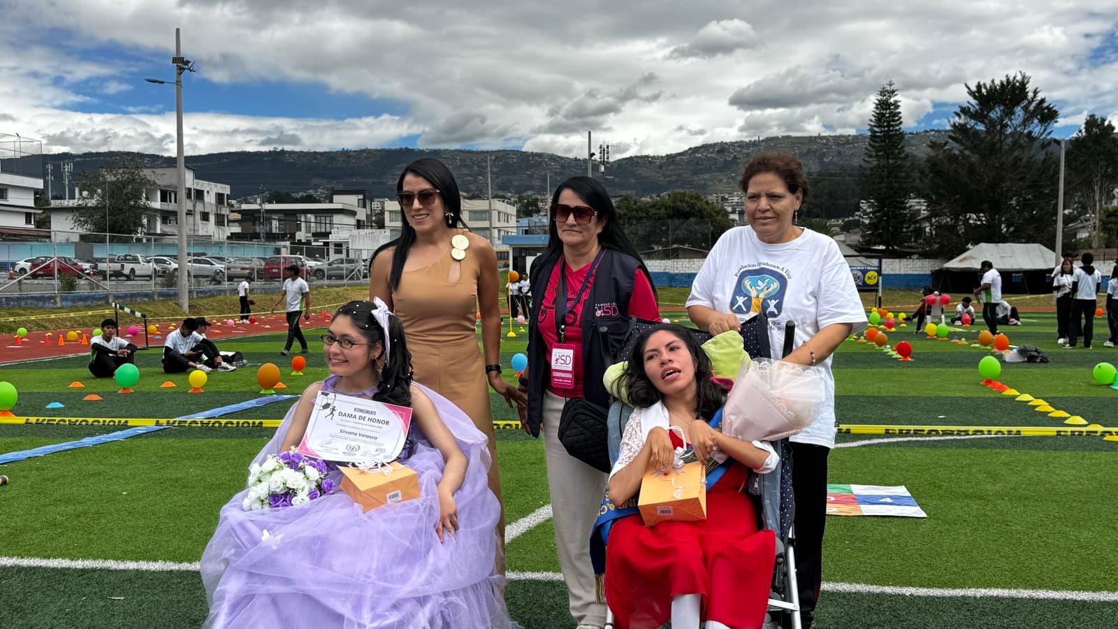 Entrega de un reconocimiento a una beneficiaria junto a su familia y voluntarios de HSD